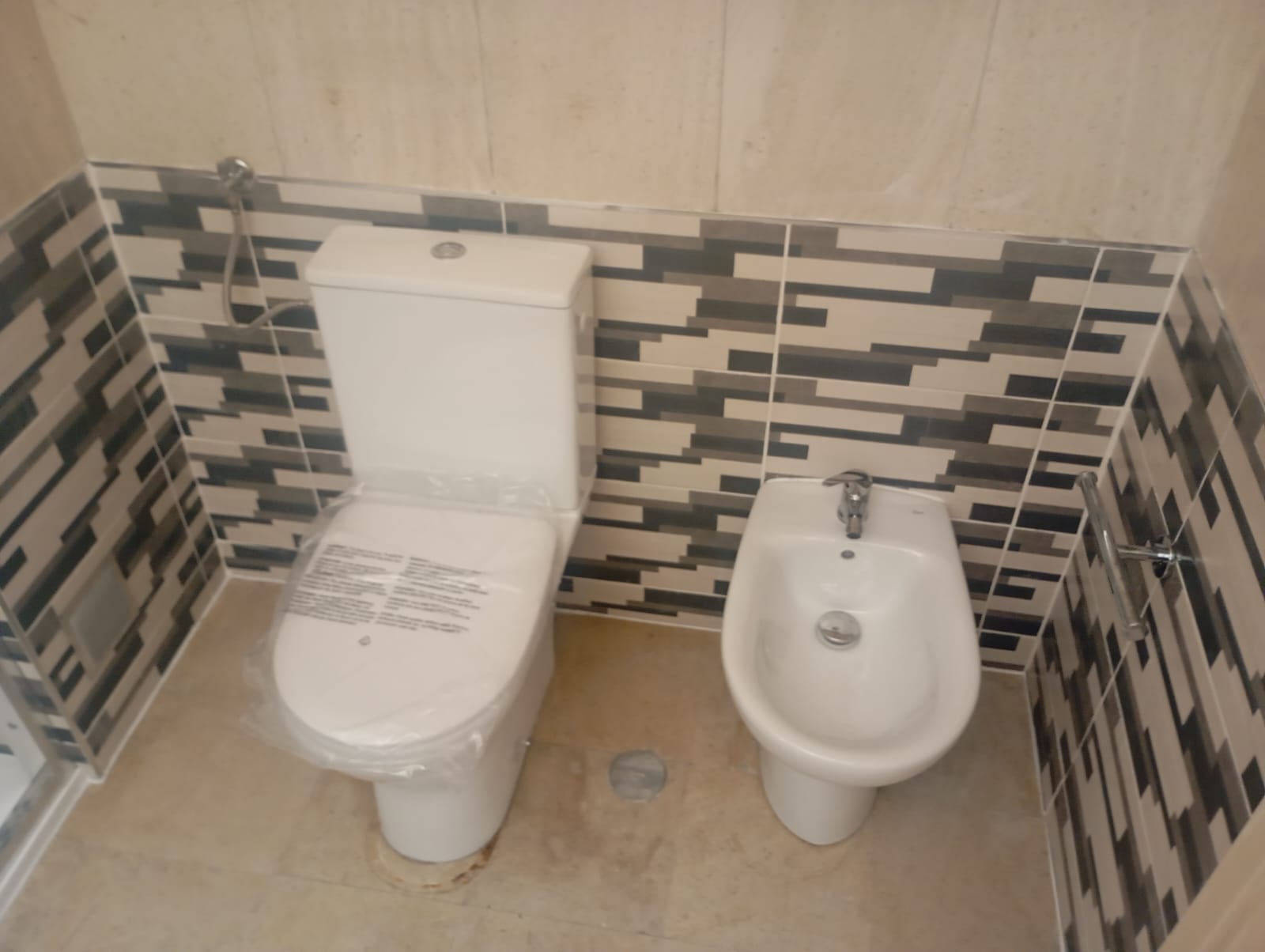 Sanita e bidé brancos com mosaico